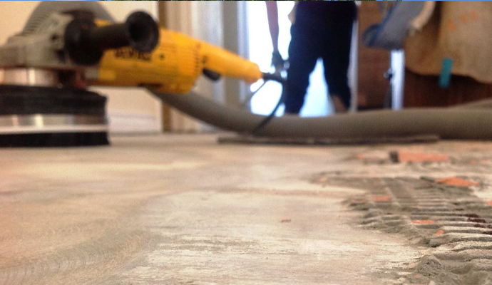 An expert using a power tool to cleaning tile dust from floor surface