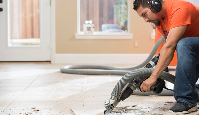 Expert worker removing tile using equipment