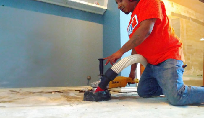 Worker grinding floor with power tools