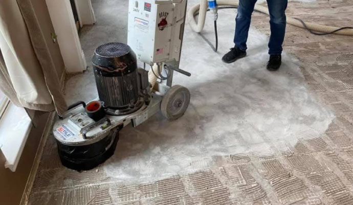 Person cleaning tiles with cleaning machine