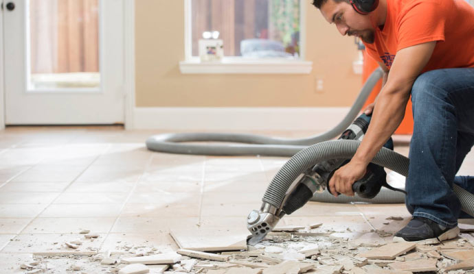 person removing tiles with equipment